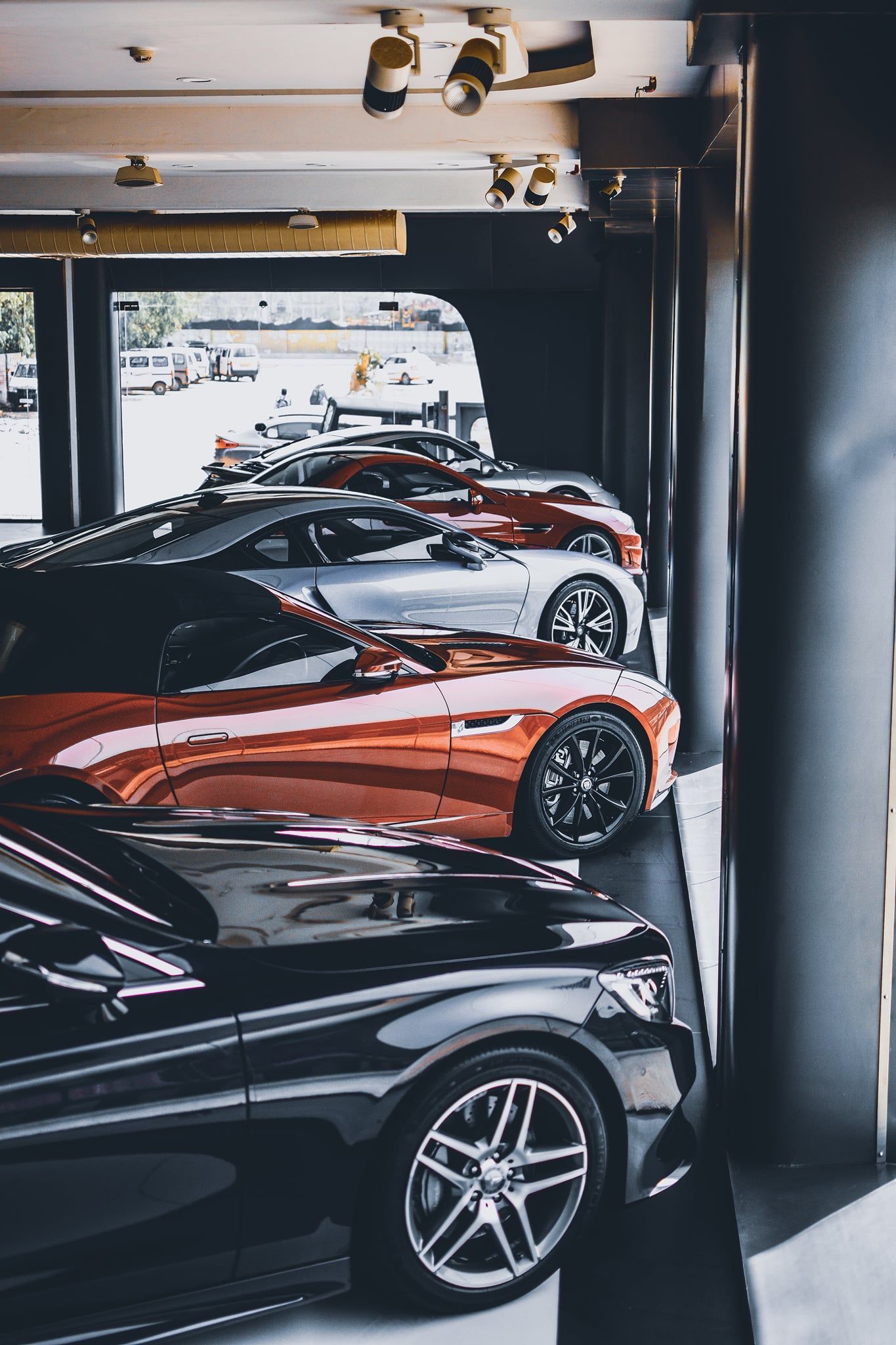 A row of cars are parked in a garage.