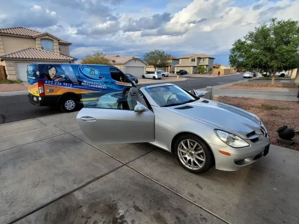 A person is applying a protective film to a black car.