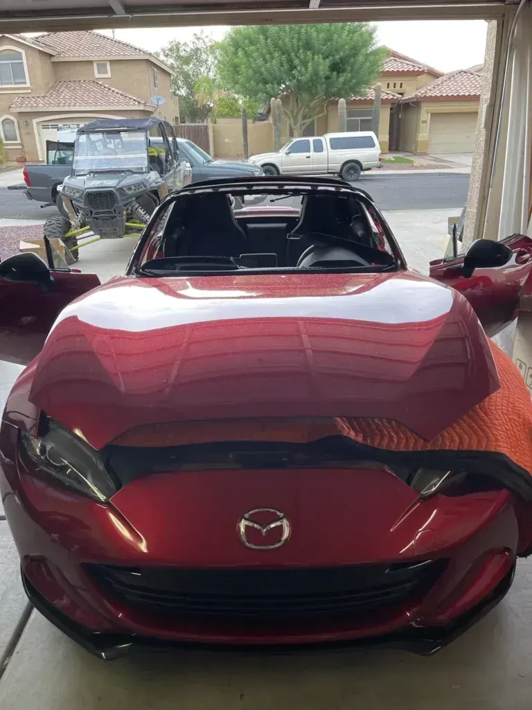 A red sports car is parked in a garage.