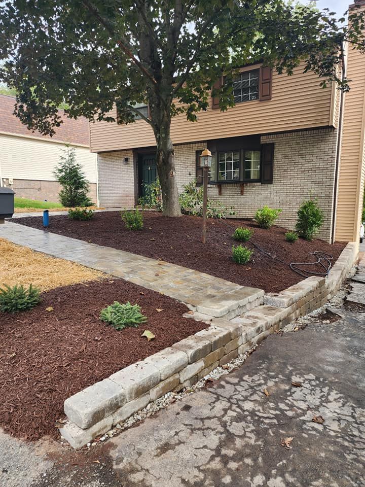 A house with a walkway and mulch in front of it.