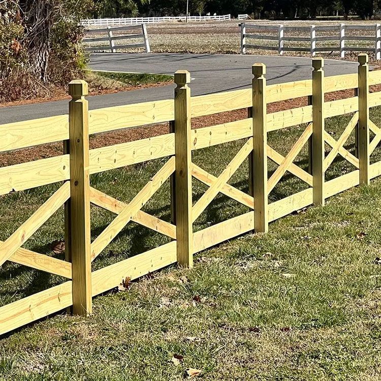 A wooden fence is sitting on top of a lush green field