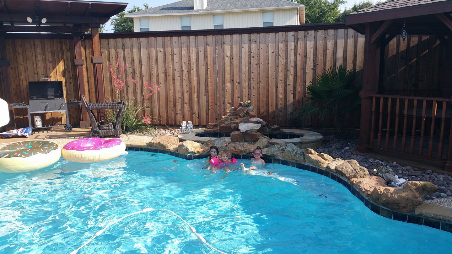 A group of people are swimming in a swimming pool.