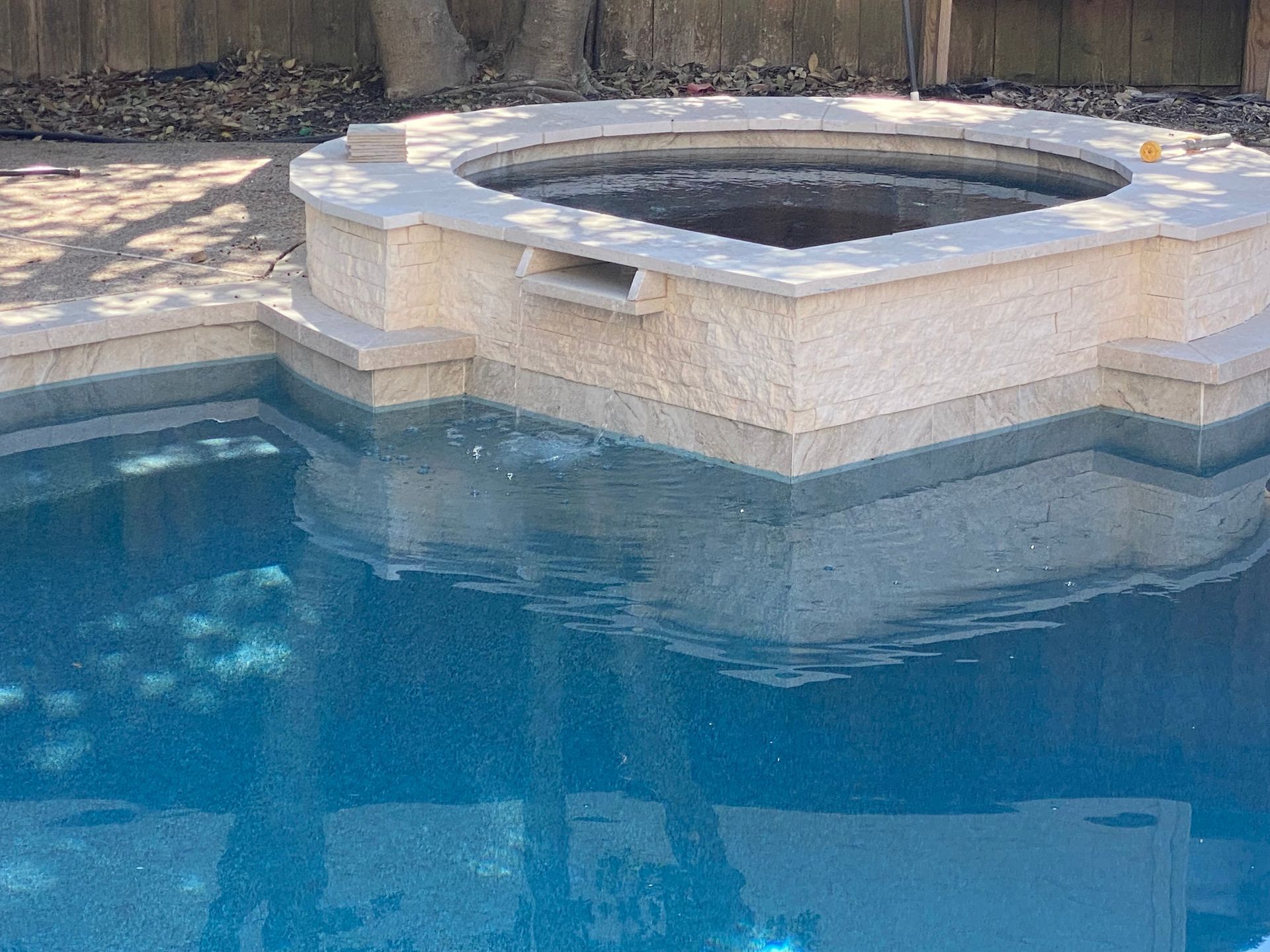 A swimming pool with a hot tub in the middle of it.