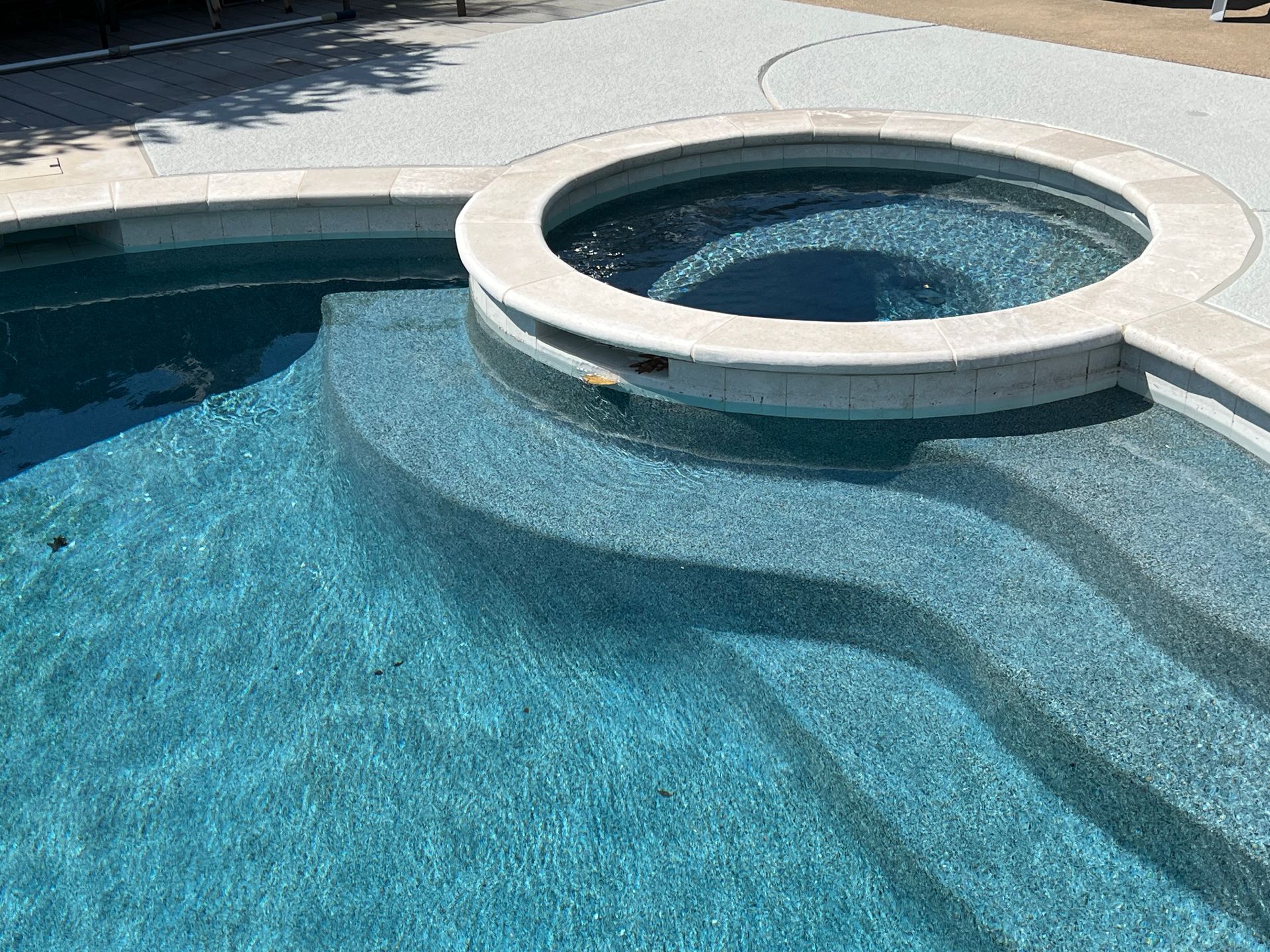 There is a hot tub in the middle of the pool.