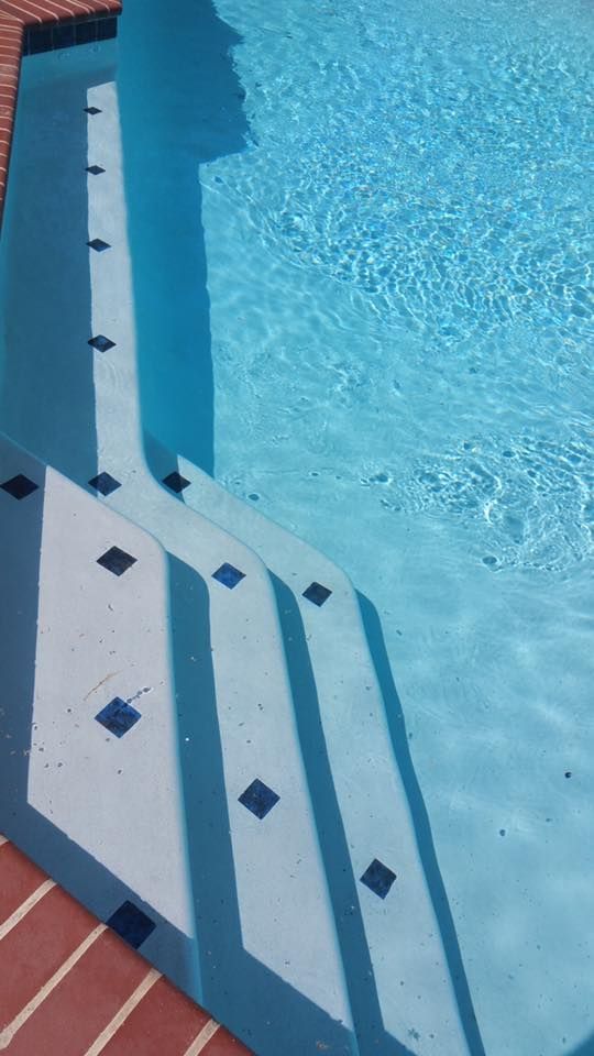 A swimming pool with stairs leading up to it