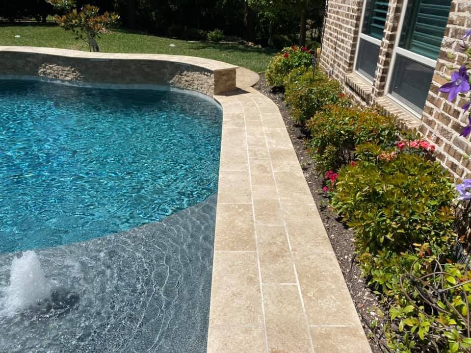 A swimming pool with a fountain in the middle of it