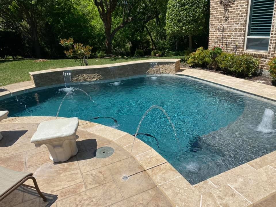 A large swimming pool with a fountain in the middle of it.
