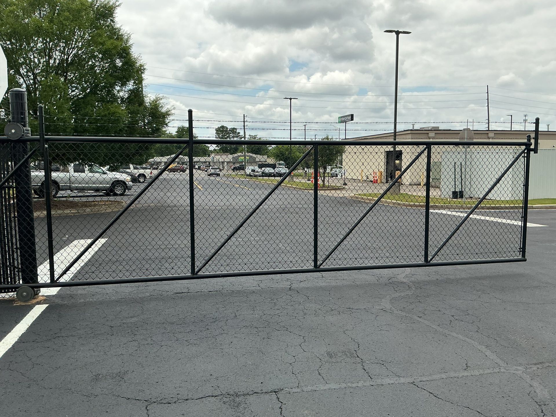 Ornate black iron fence with pointed finials along a tree-lined path