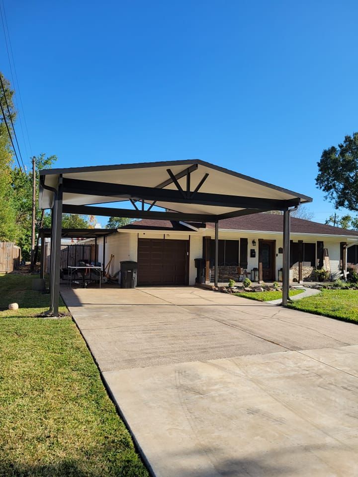 A carport over a concrete driveway in front of a one-story house with a brown garage door, on a sunny day.