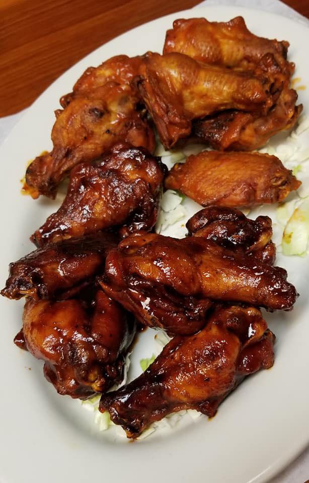 A white plate topped with chicken wings and lettuce