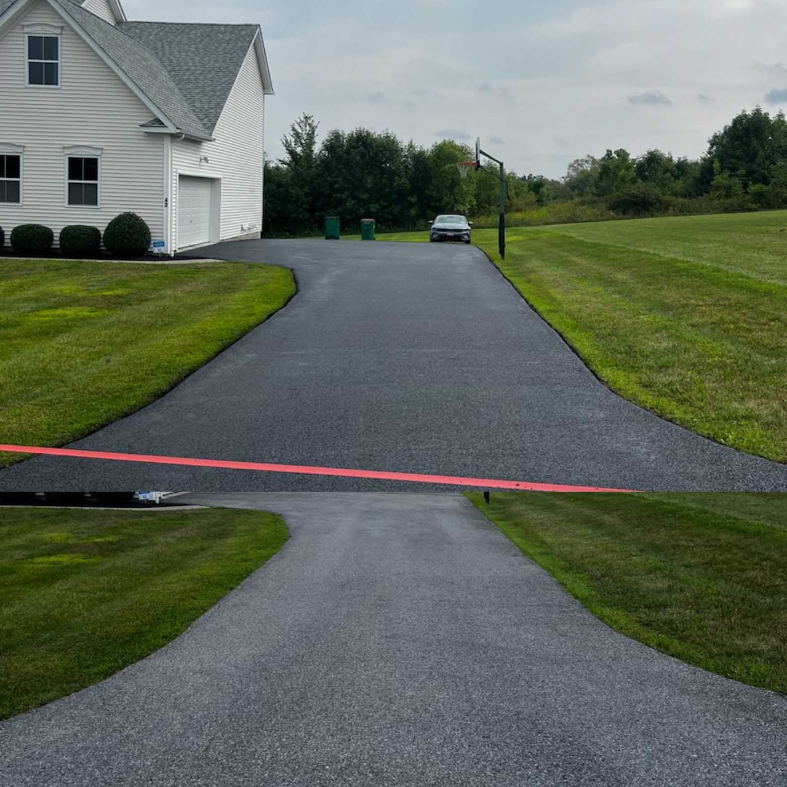 A car is driving down a driveway next to a house.