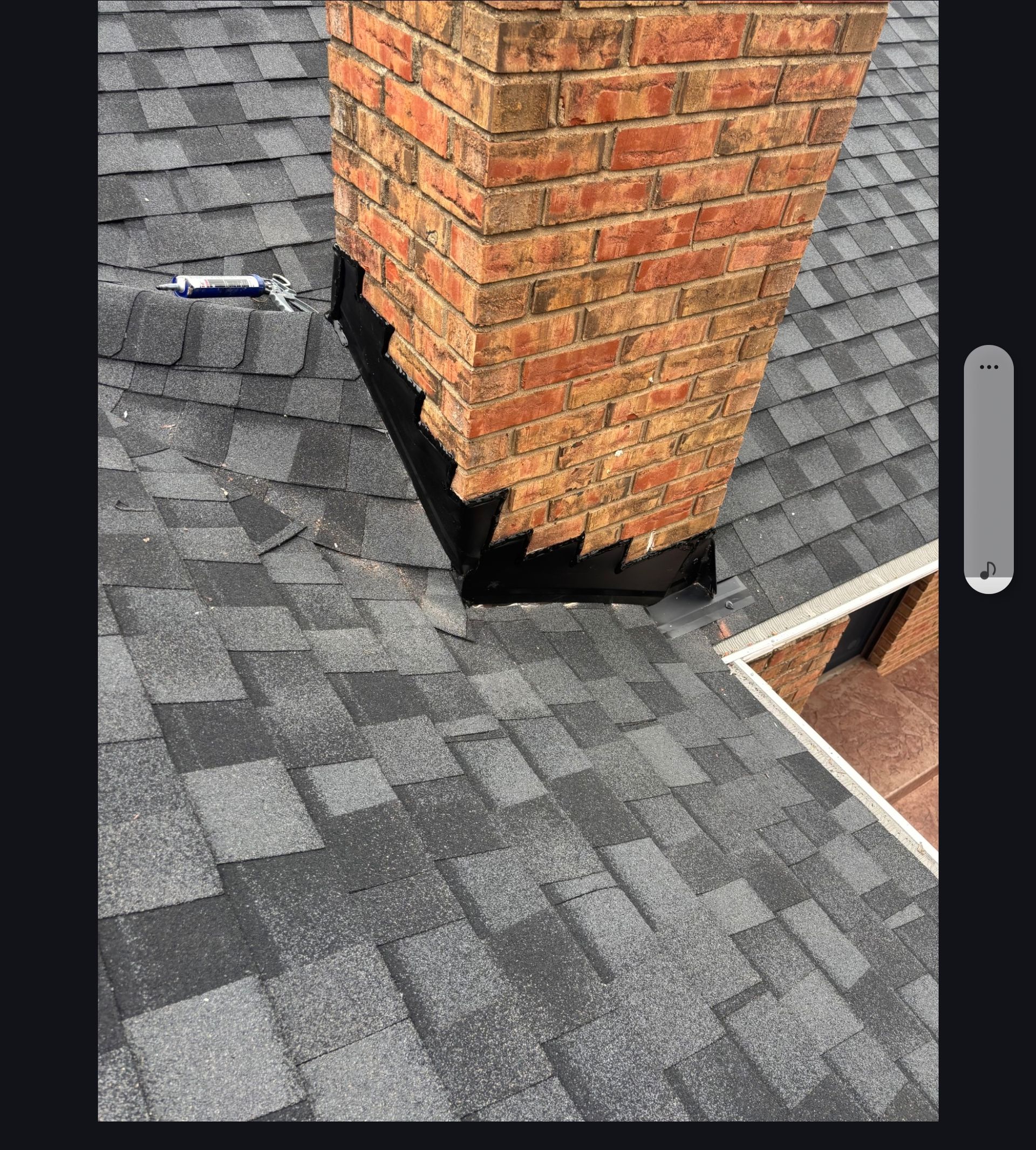 Gray shingle roof with a large brick chimney and a small roof vent opening.