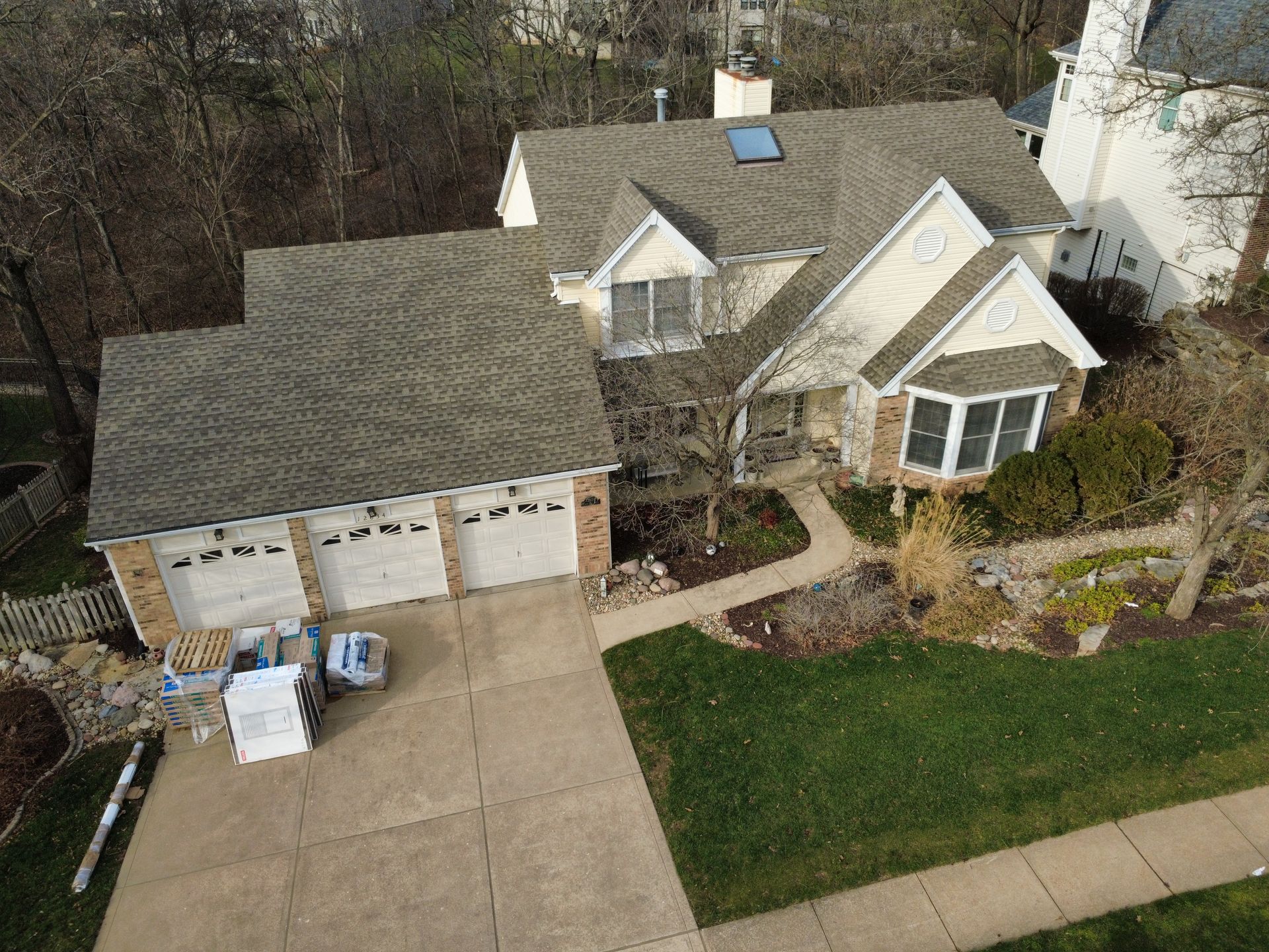 Aerial view of a suburban house with a two-car garage, driveway, and front lawn