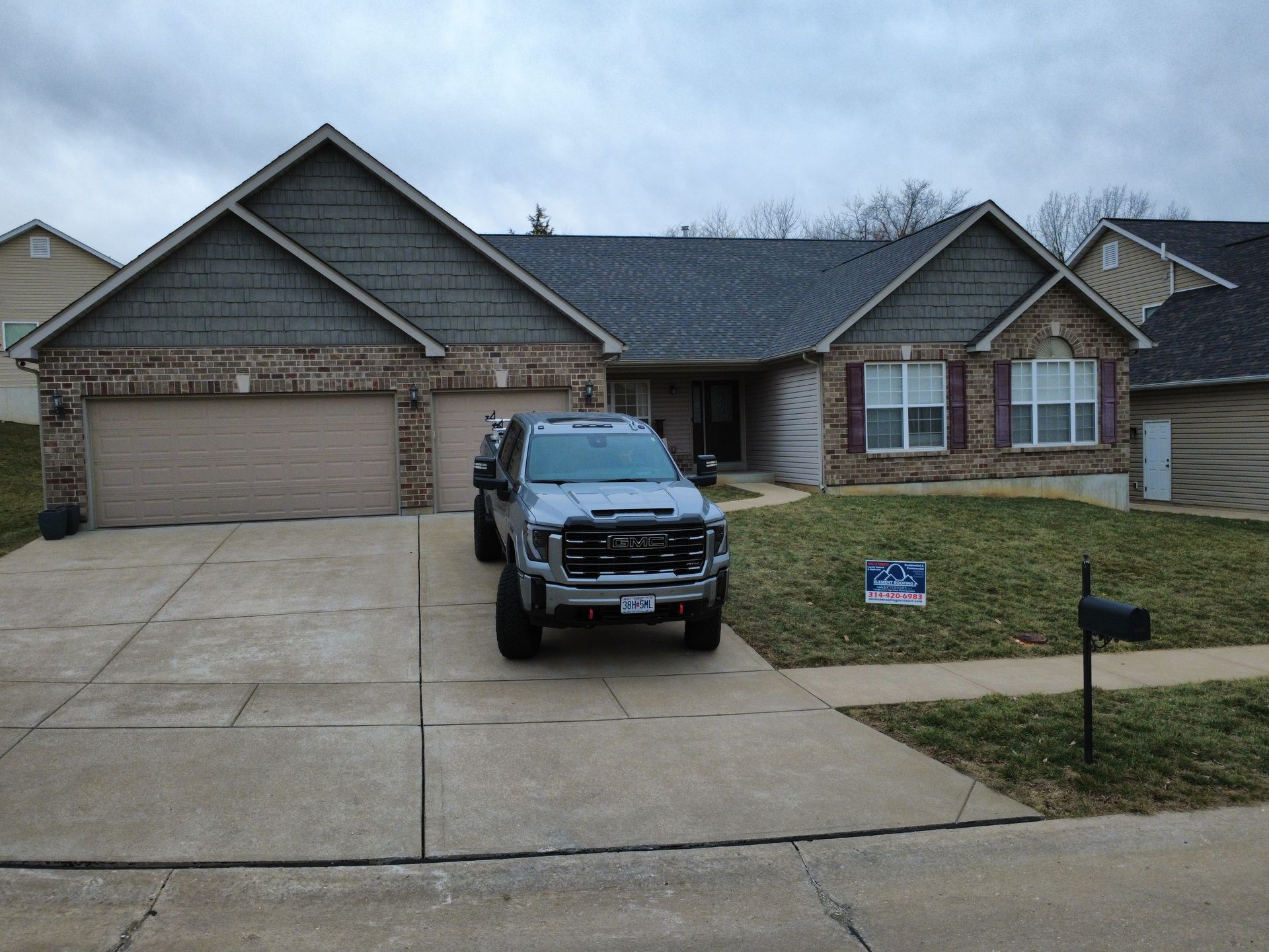Suburban brick house with a black pickup truck parked in the driveway