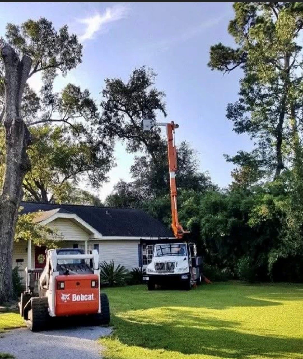 A bobcat truck is parked in front of a house