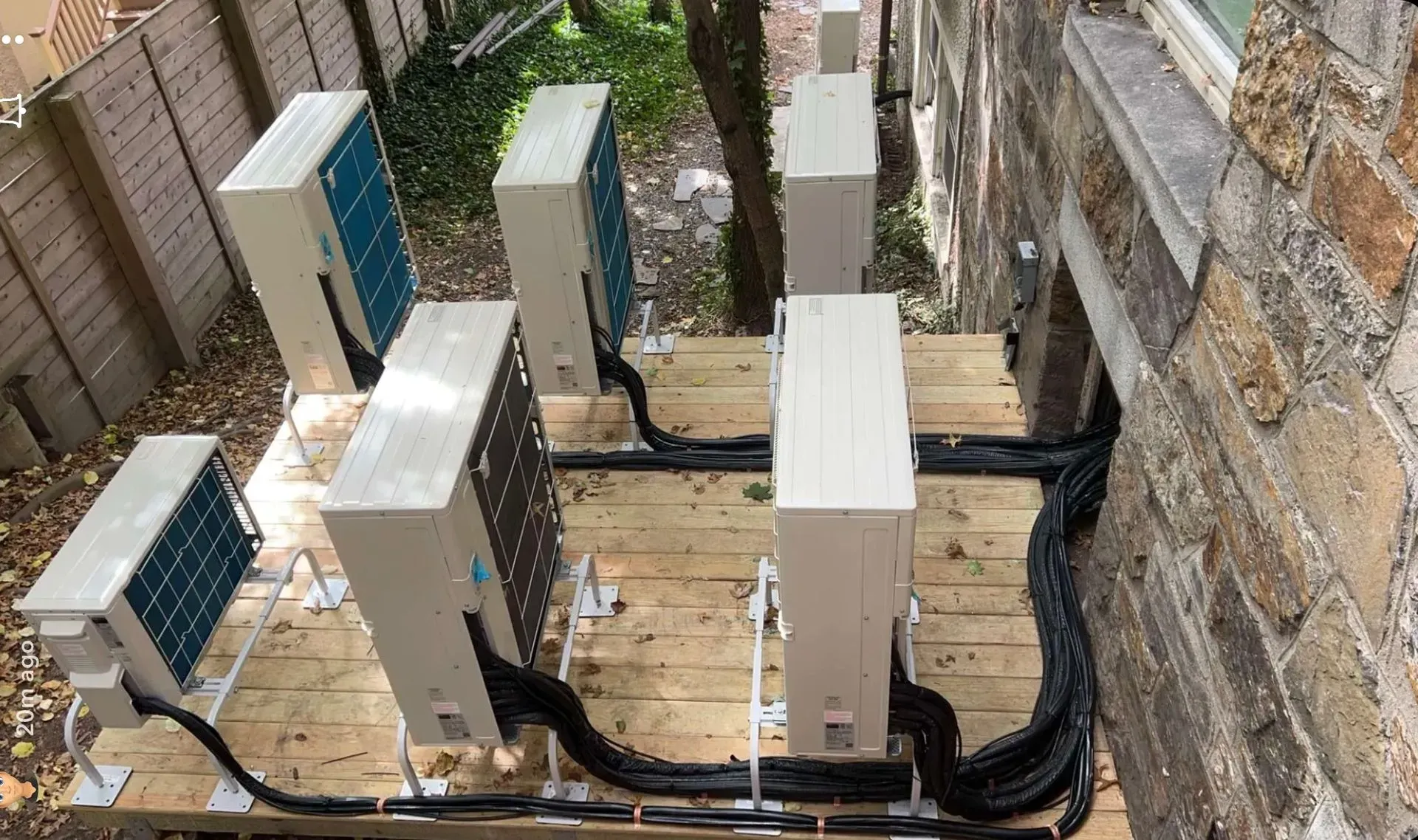 Outdoor view of electrical utility boxes and cables beside a brick wall