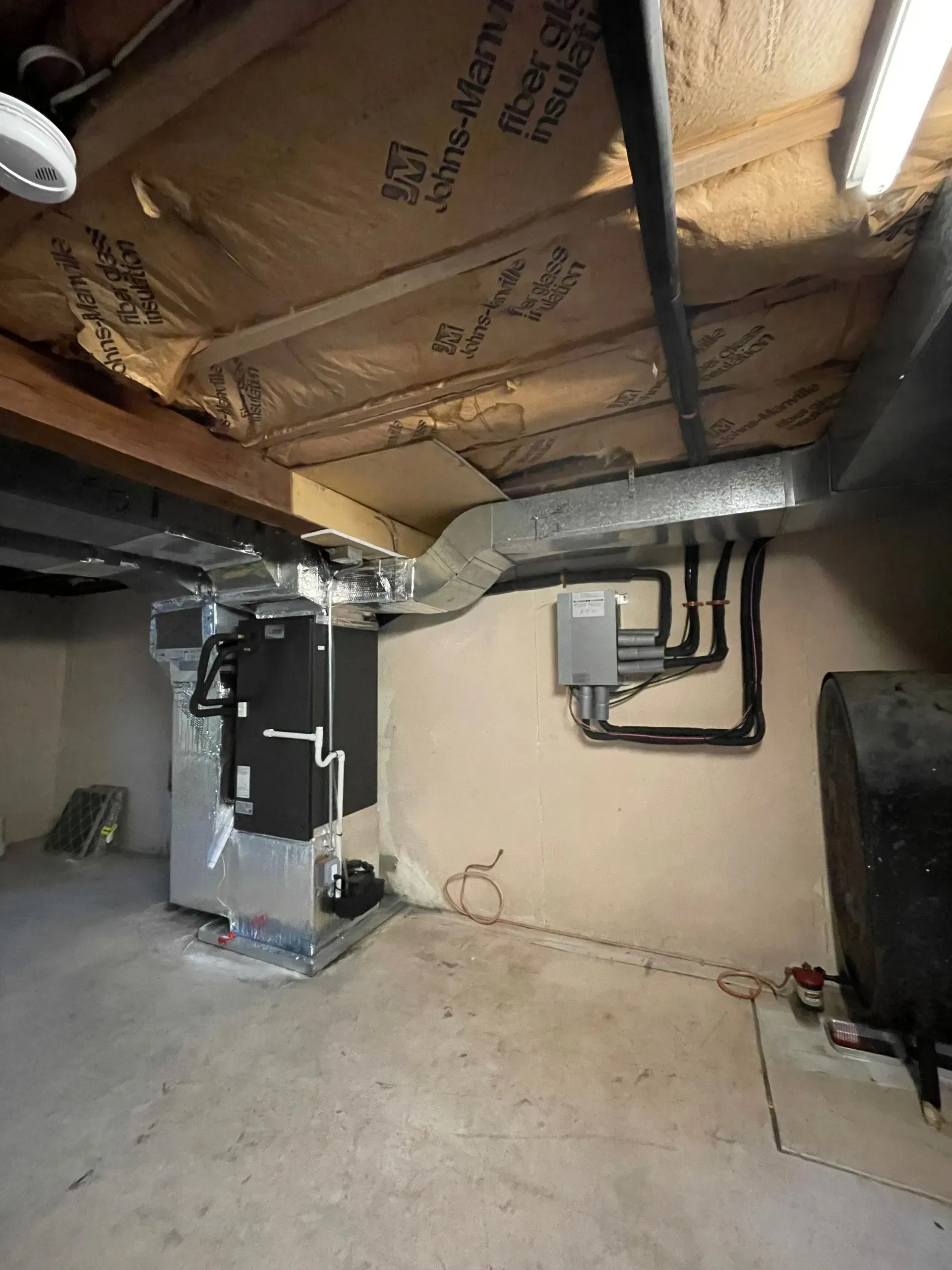 Basement utility room with furnace, exposed ductwork, and unfinished insulated ceiling and walls