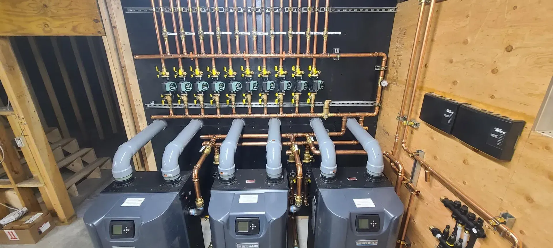 Electrical panel with multiple gray circuit breakers and wiring in a wooden utility enclosure