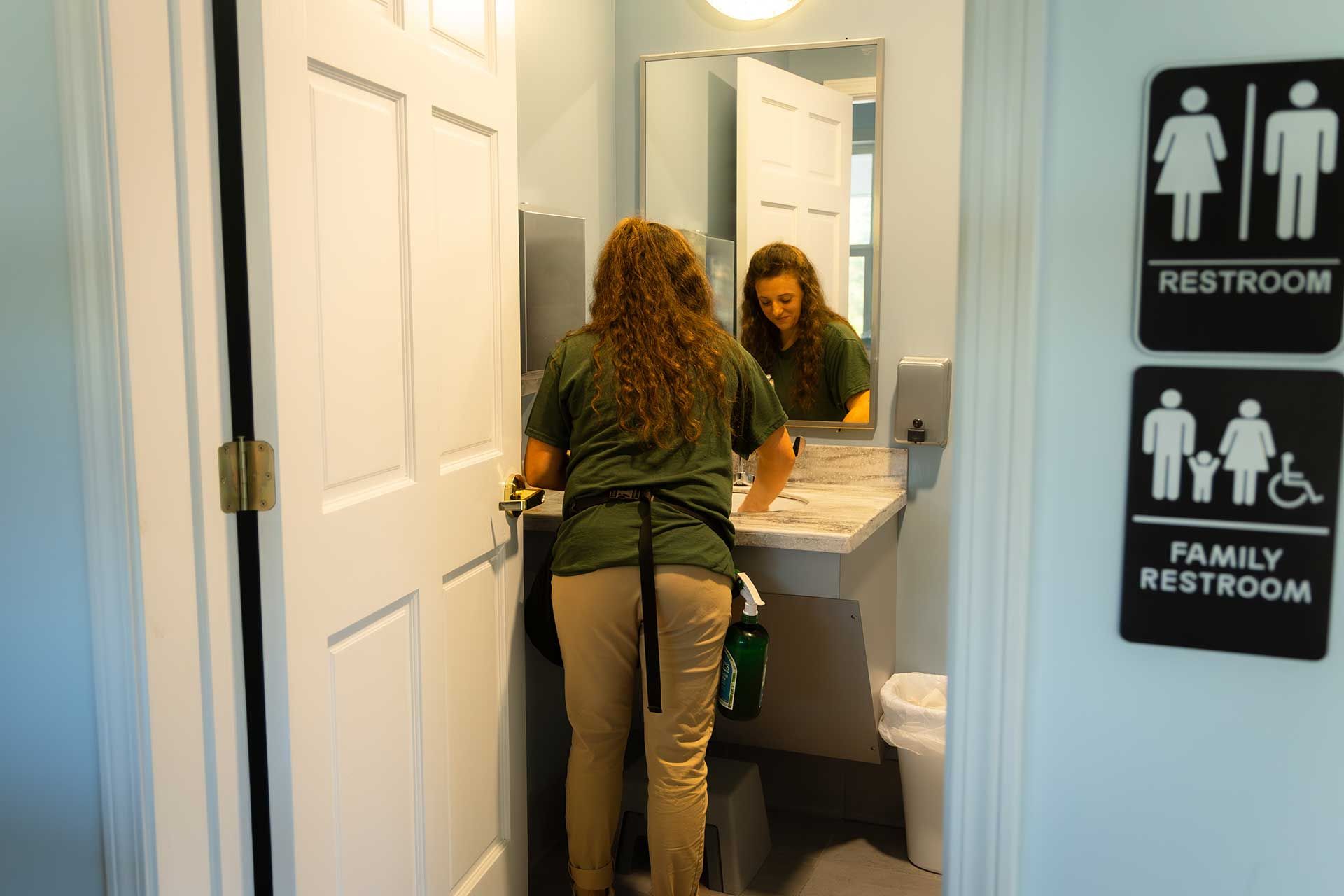 a person cleaning a bathroom sink