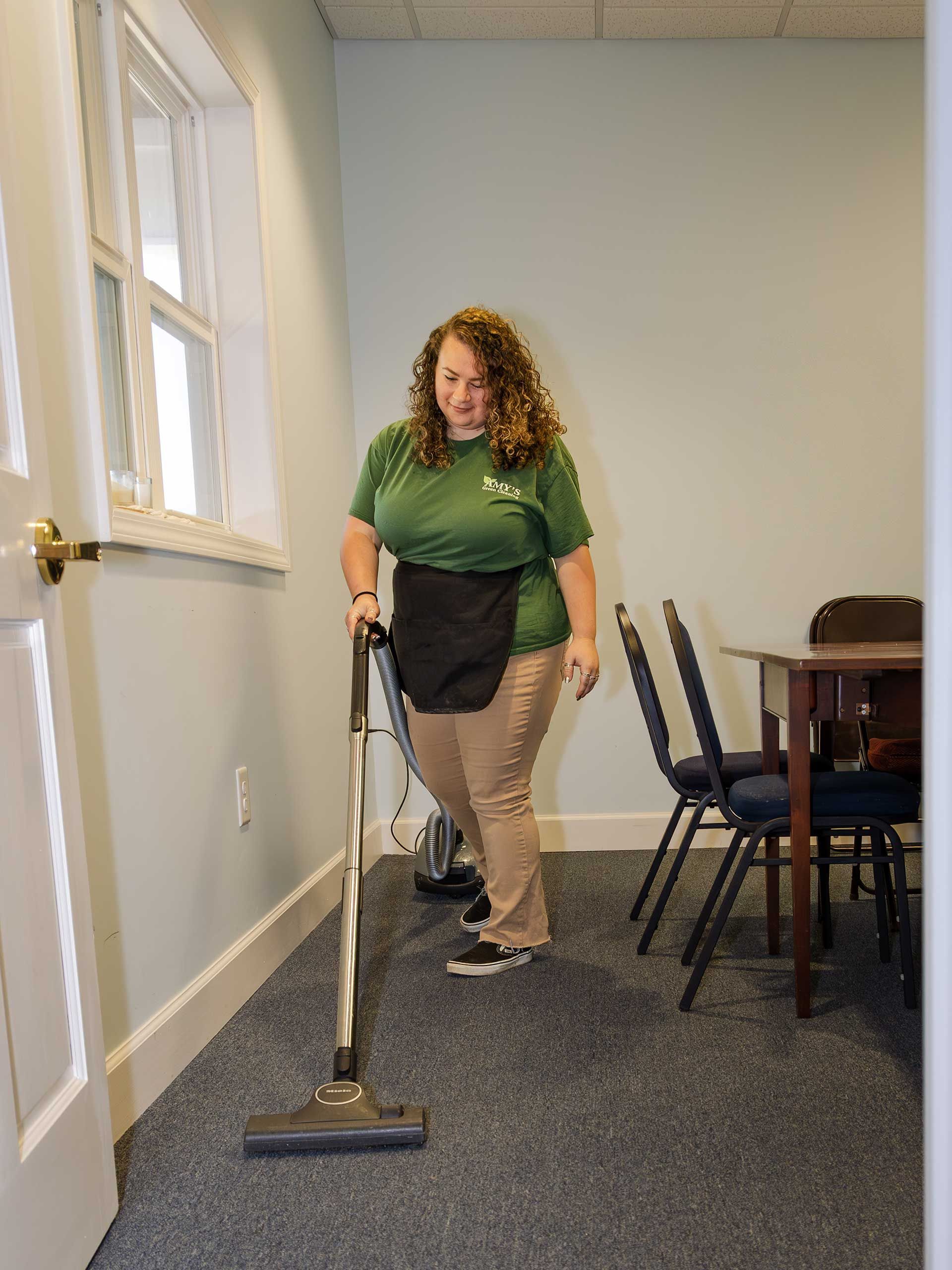 a woman vacuuming a carpeted room