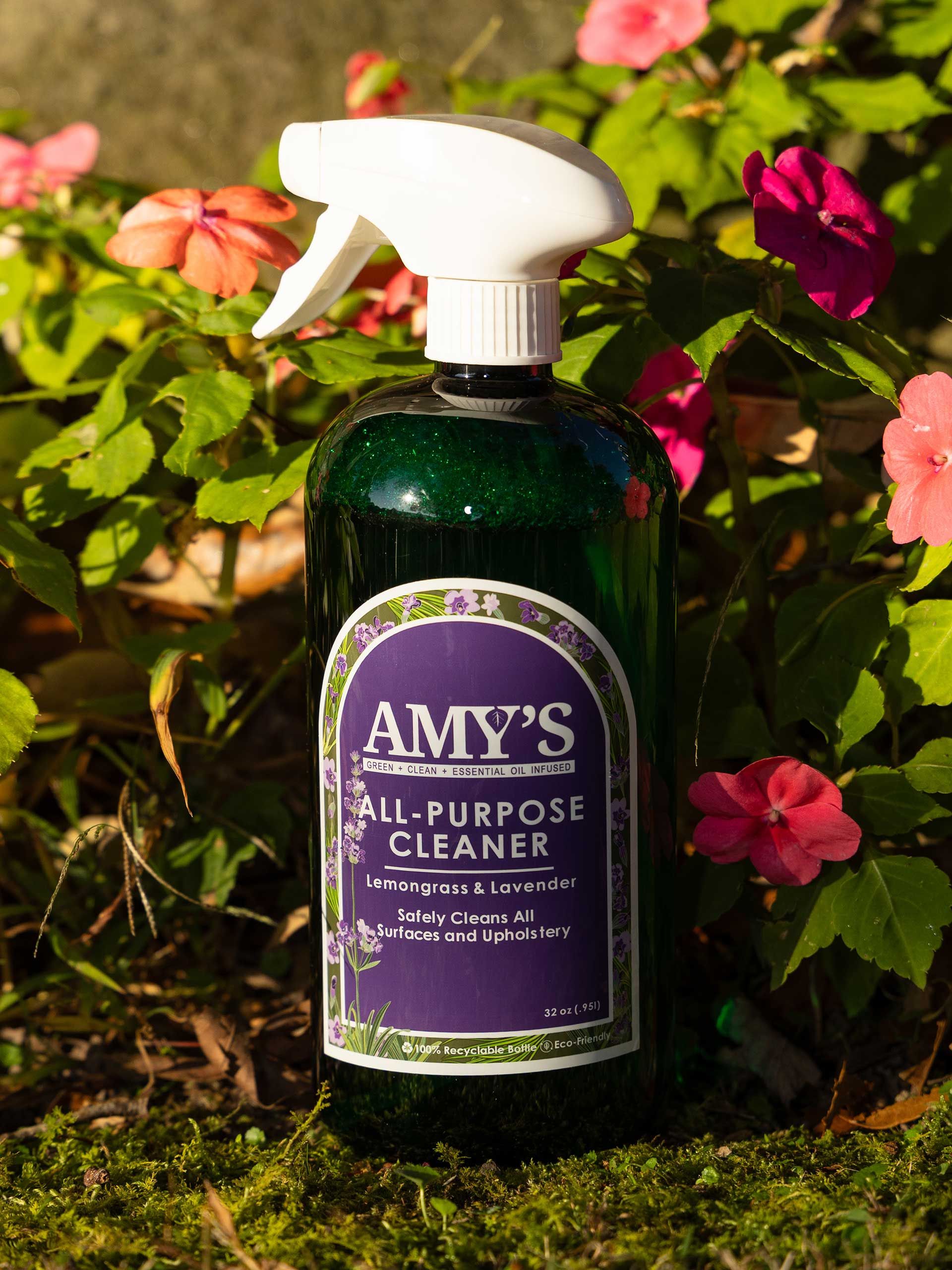 a bottle of Amy's All-Purpose Cleaner, white spray nozzle, in front of pink flowers and greenery