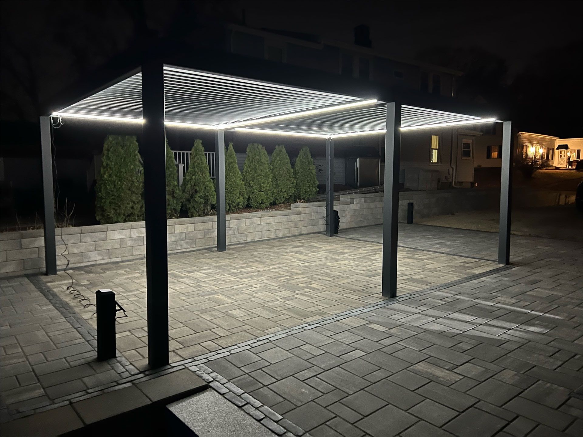 A carport with lights on it is lit up at night