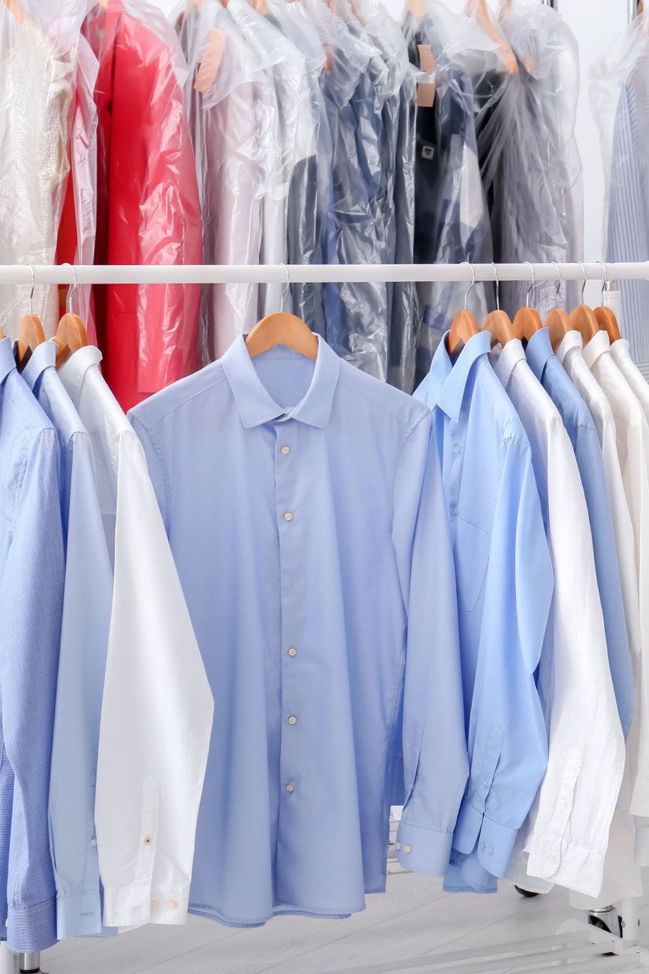 A row of shirts hanging on a rack in a dry cleaner
