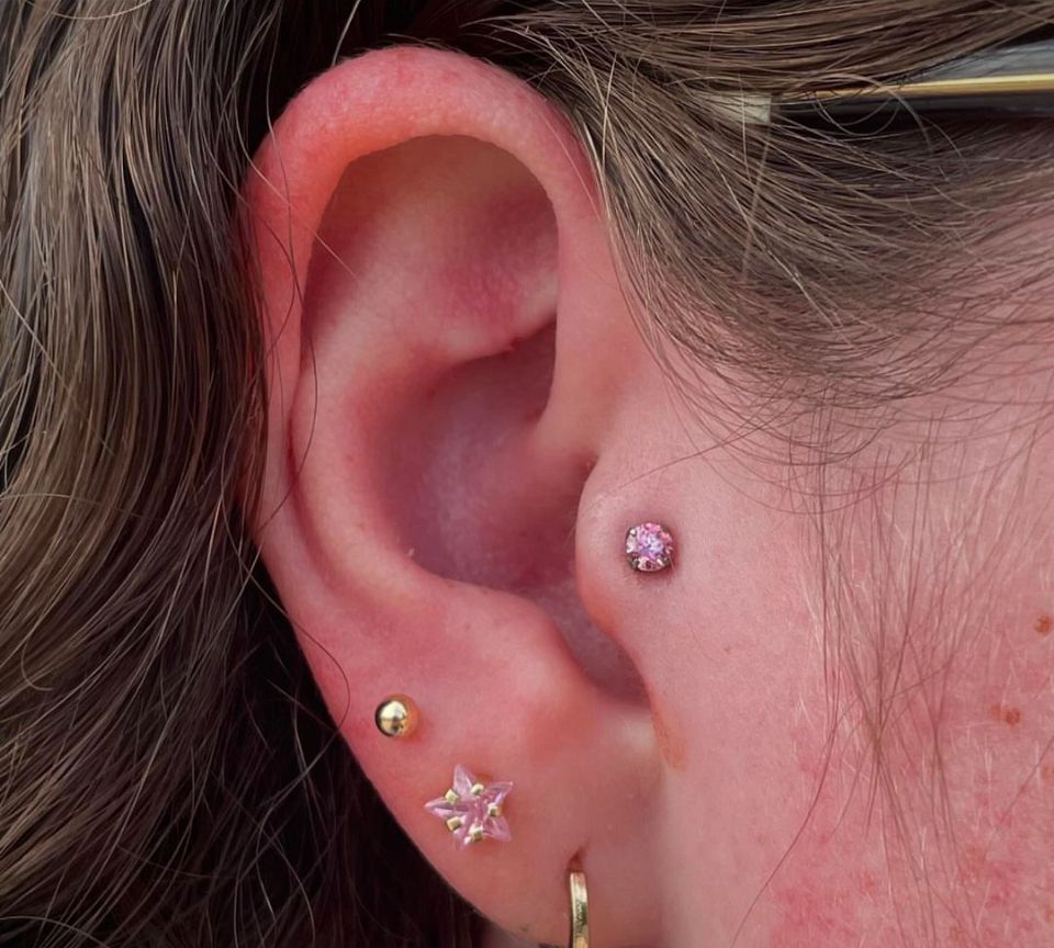 A close-up of a woman's ear with multiple piercings