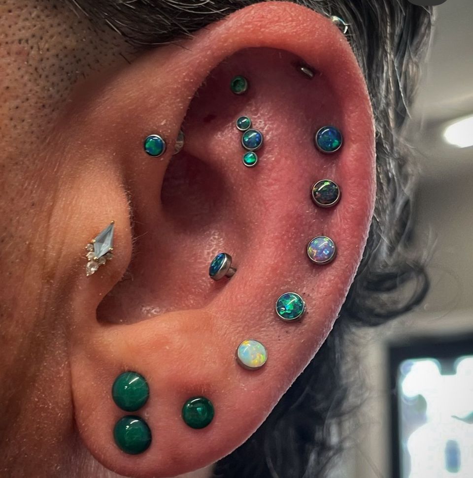 A close-up of a woman's ear with multiple piercings