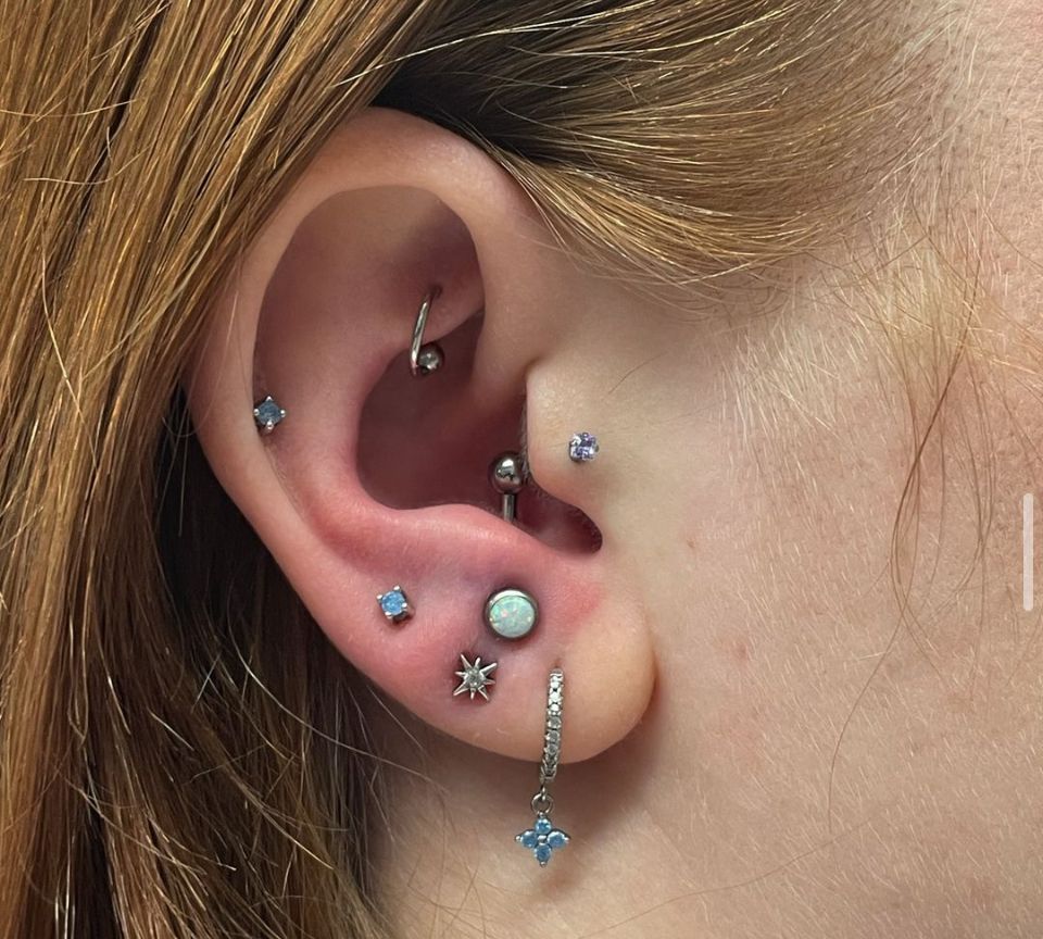 A close-up of a woman's ear with multiple piercings