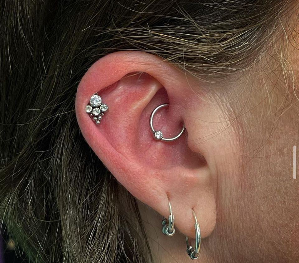 A close-up of a woman's ear with multiple piercings