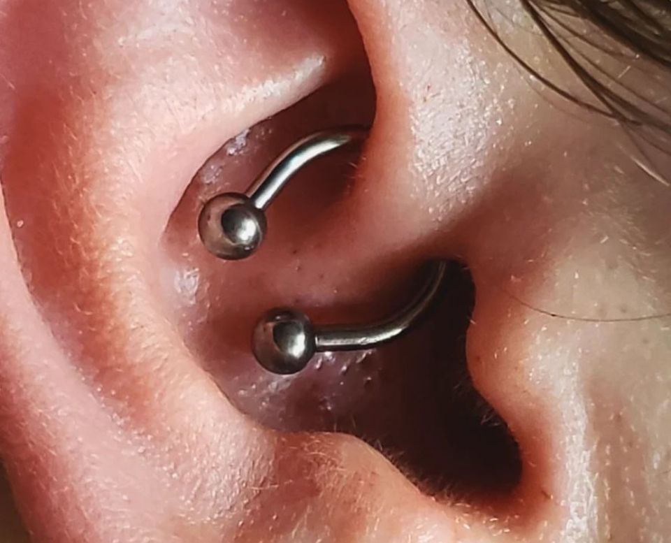 A close-up of a person's ear with a piercing in it