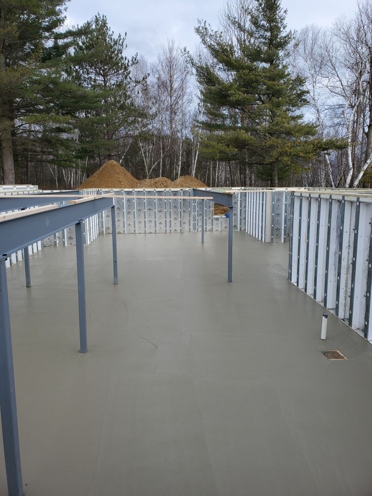 a concrete floor with a fence in the background and trees in the background