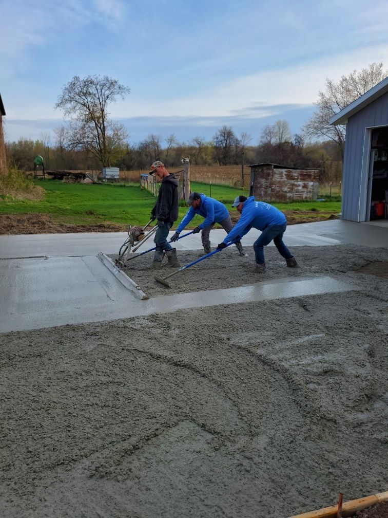 a group of men are working on a concrete driveway