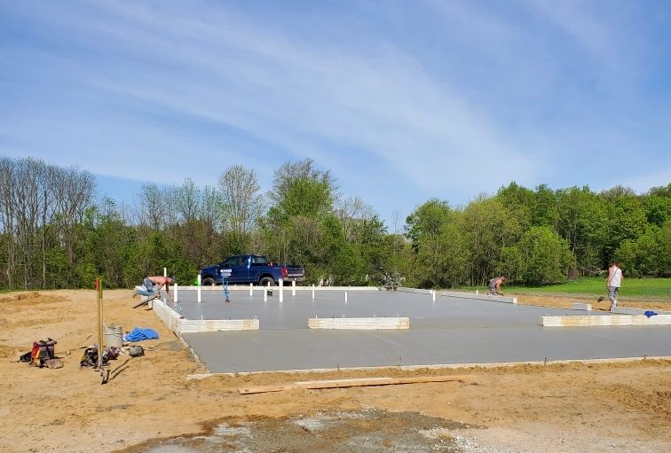 a concrete foundation is being built in a dirt field