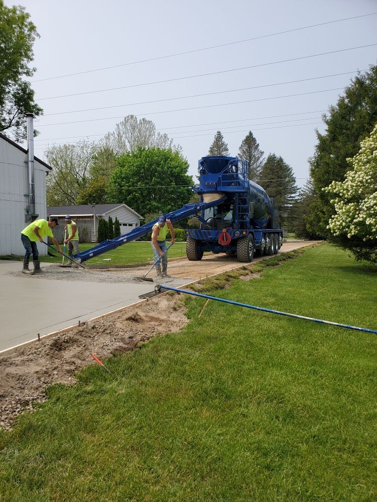 a concrete truck is pouring concrete into a driveway