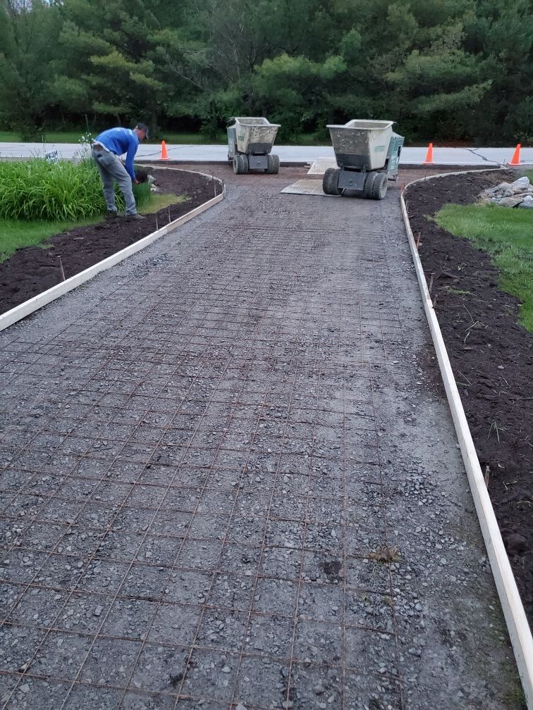a man is laying concrete on a driveway