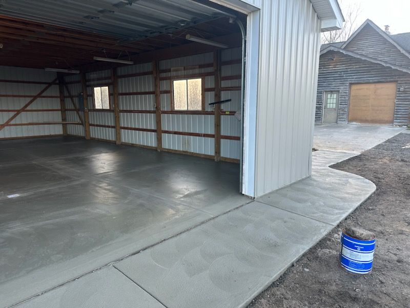 a garage with the door open and a sidewalk in front of it