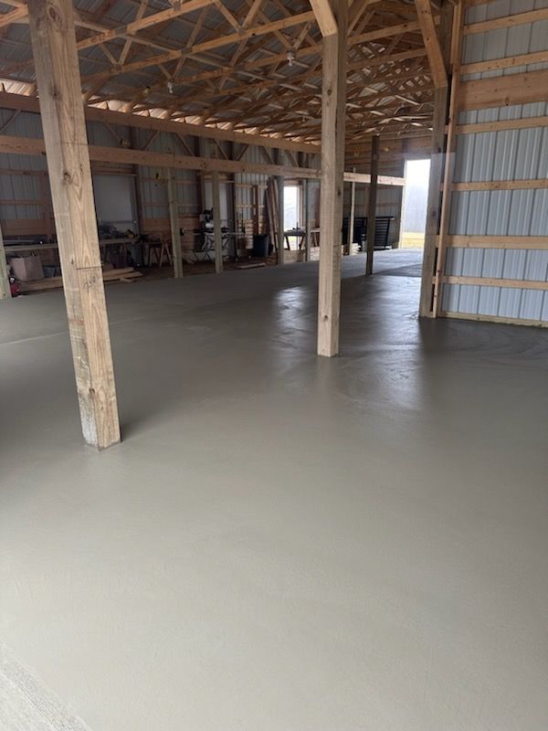 a large warehouse with a concrete floor and wooden beams