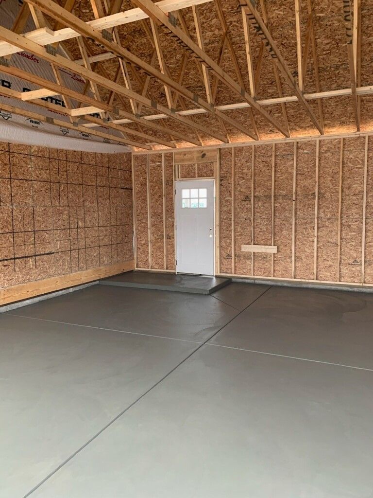 a garage under construction with a white door and wooden walls