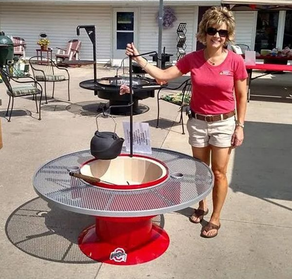 Woman beside a red-and-silver outdoor kettle grill with a hanging pot on a patio