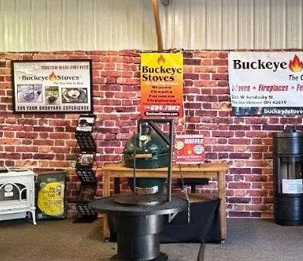 Display of Buckeye Stoves with several wood stoves and brick-wall signs in a showroom