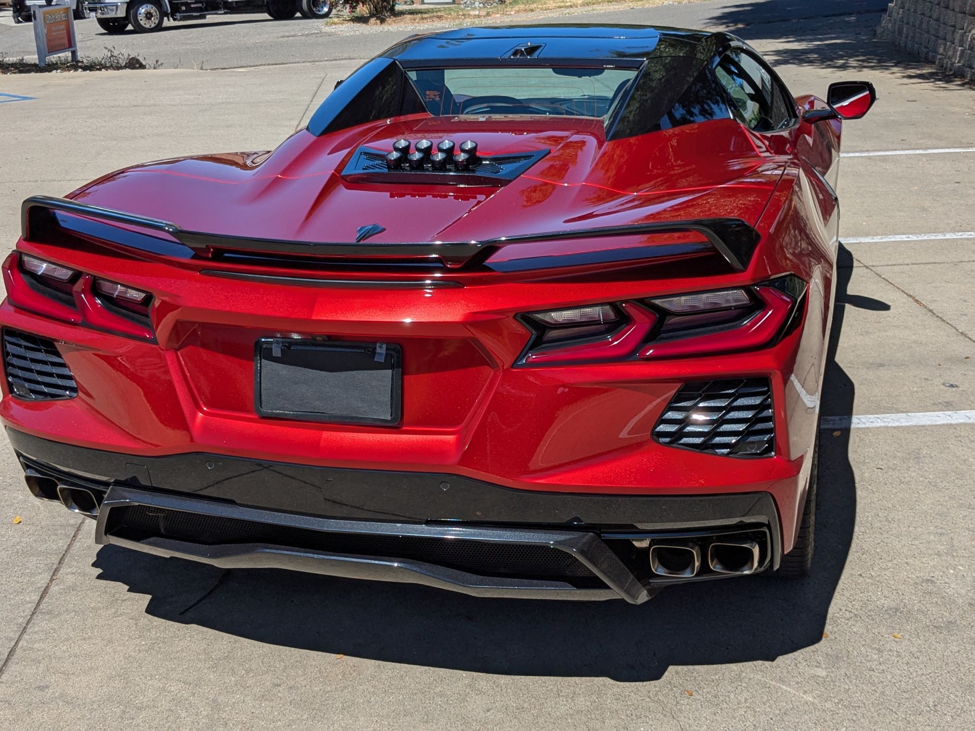 A red sports car is parked in a parking lot.