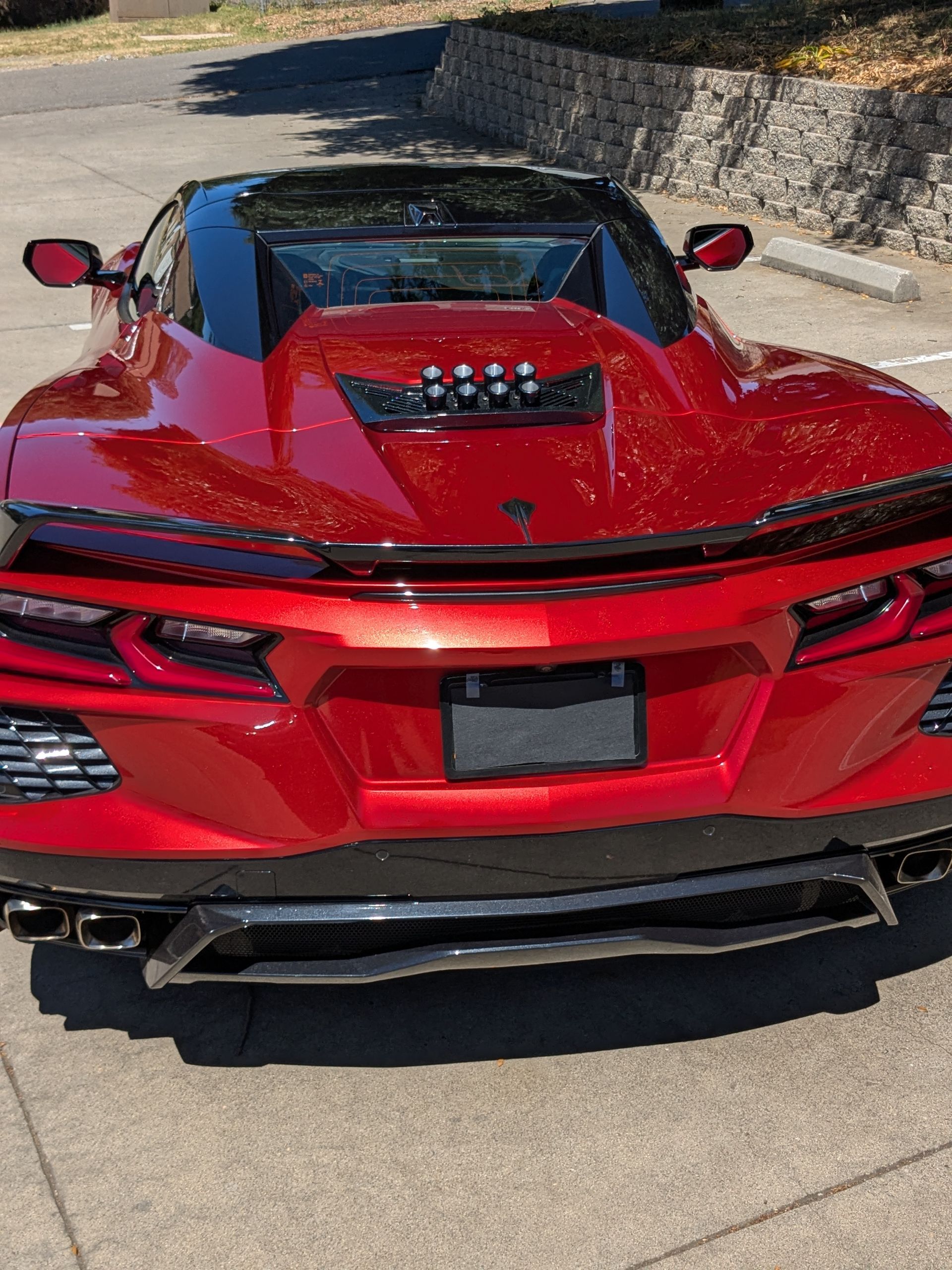 A red sports car is parked on the side of the road
