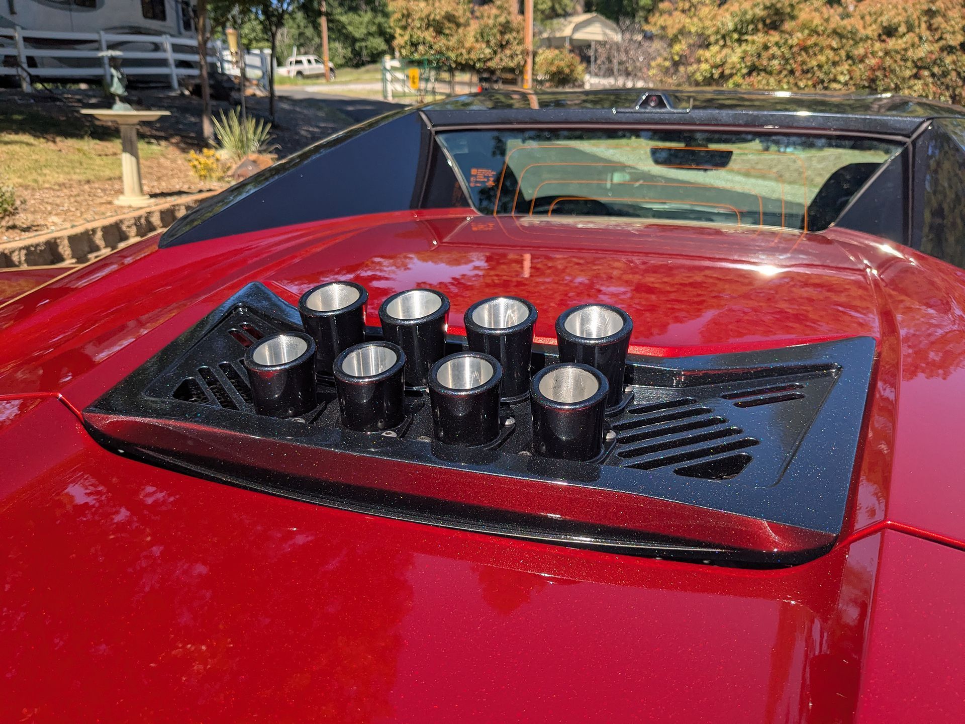 A red car with a black grille on the hood