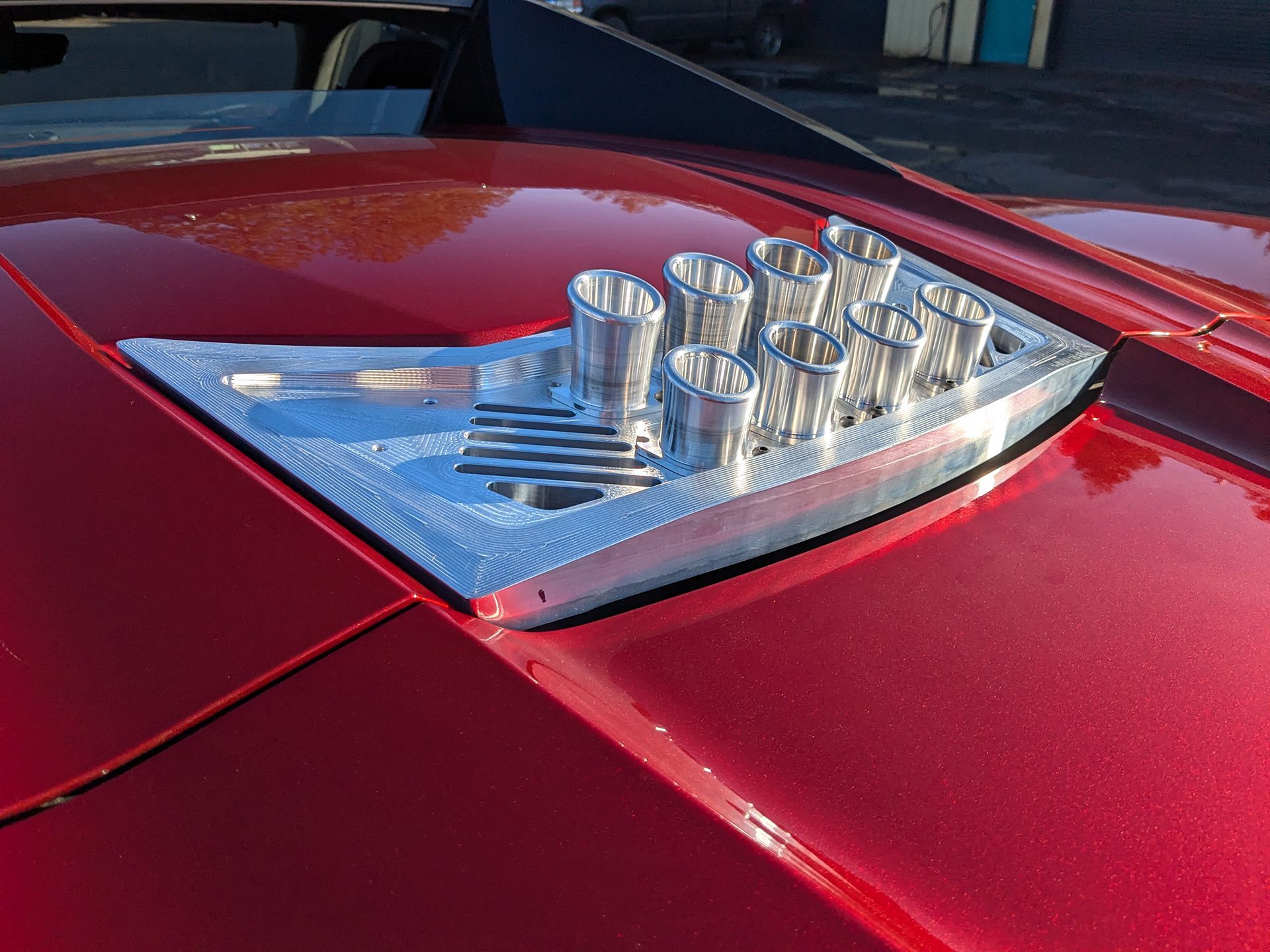 A red car with a heat vent