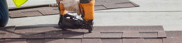 Worker putting the asphalt roofing