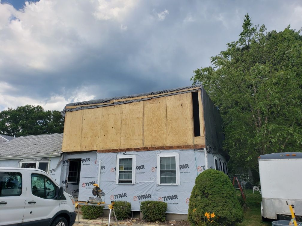 A white van is parked in front of a house that is being remodeled.
