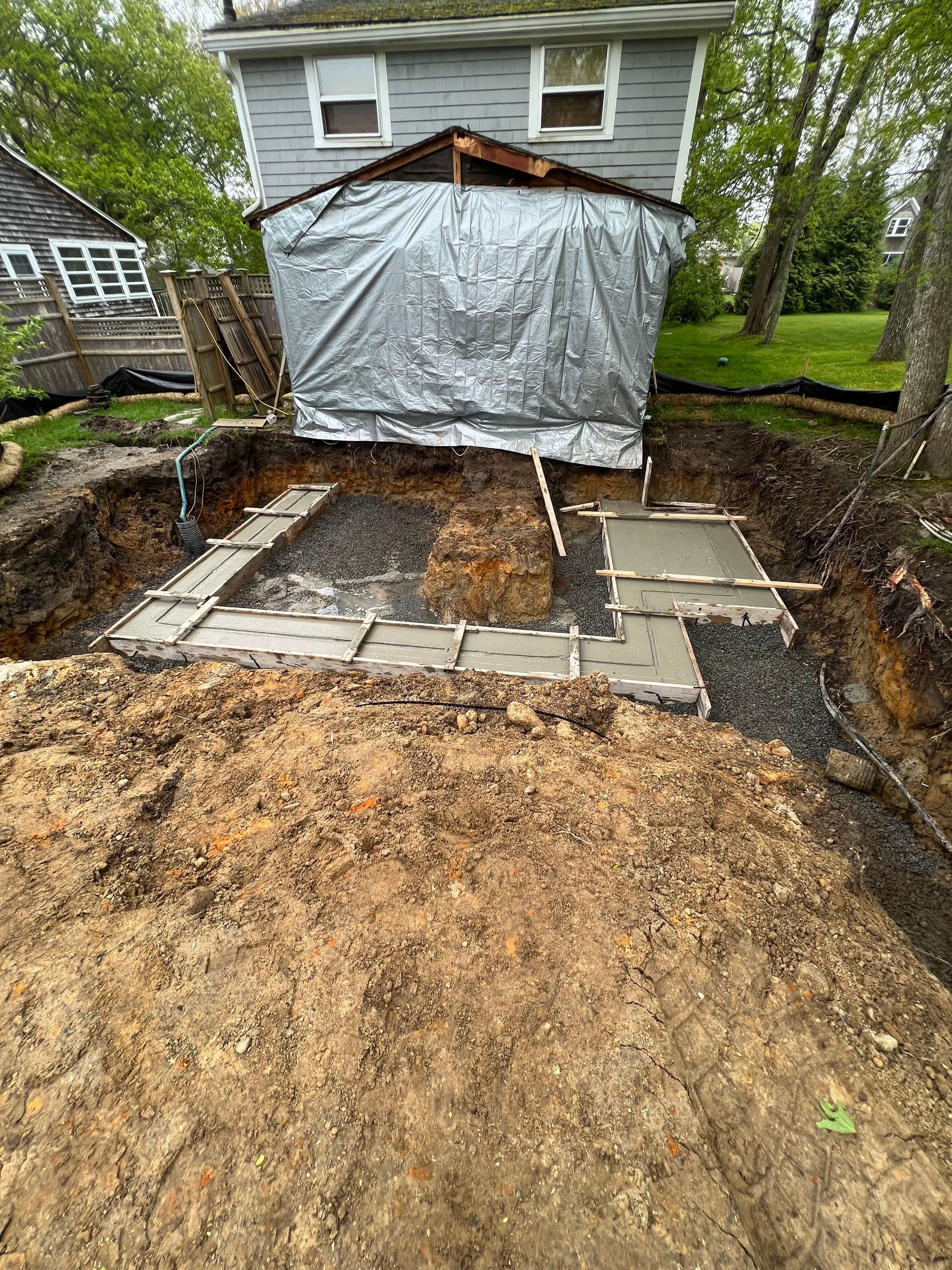 A house is being built in the dirt next to a large pile of dirt.