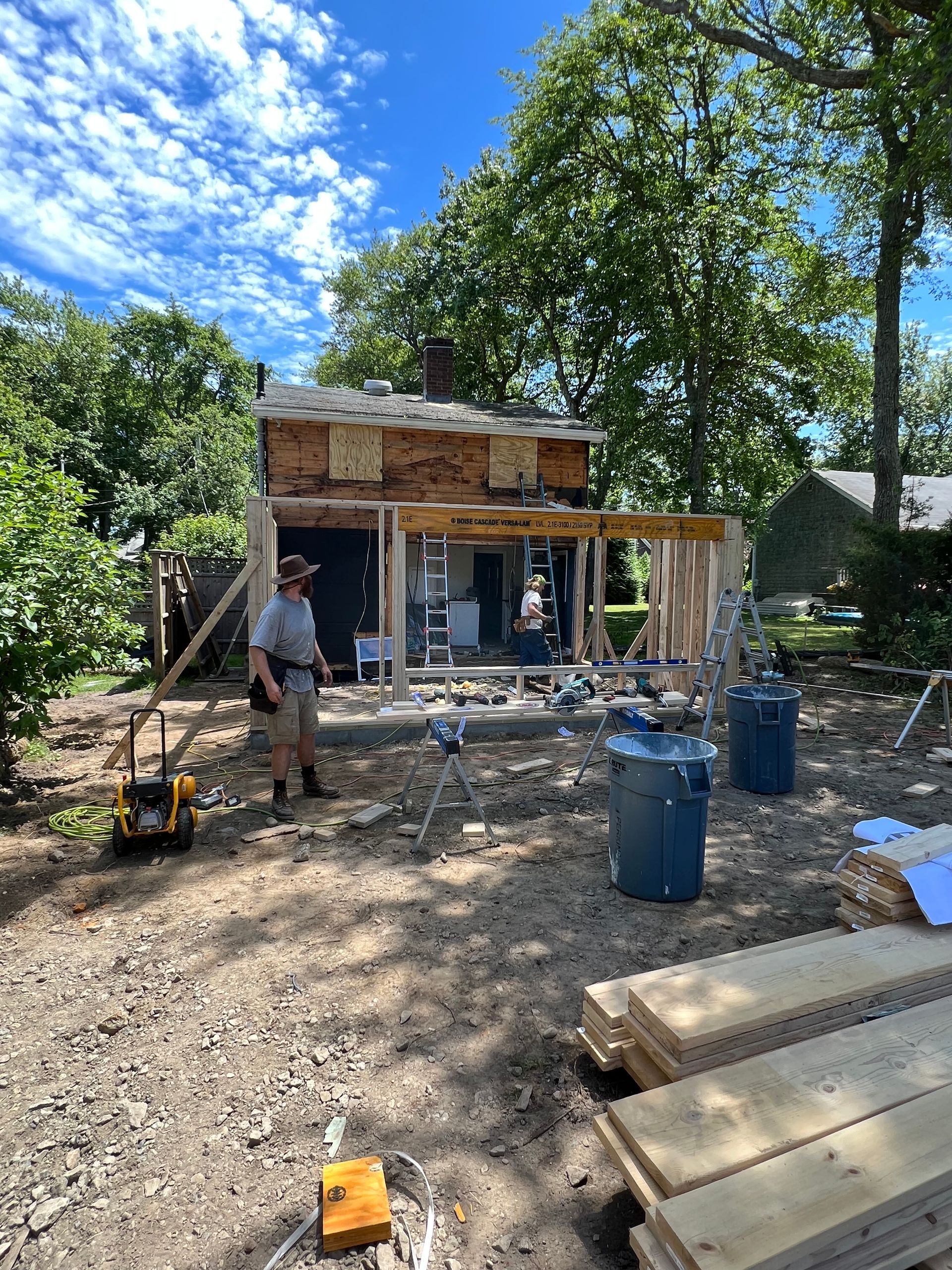 A man is standing in front of a house under construction.